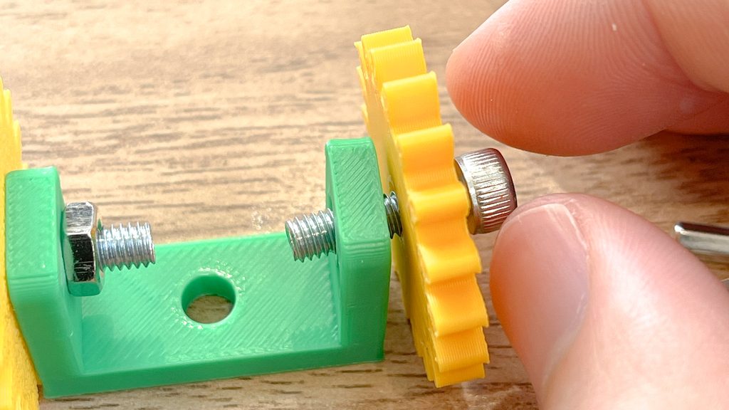 ネジと工具を使ってブロックの構造を組み立てる子ども